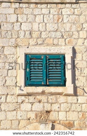 Green window with wood shutters closed on the facade of a stone house, Dubrovnik, Croatia
