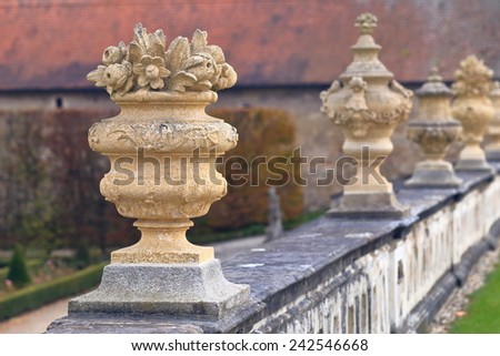 Row of stone carved pots decorate a fence of the medieval castle garden, Cesky Krumlov, Czech Republic
