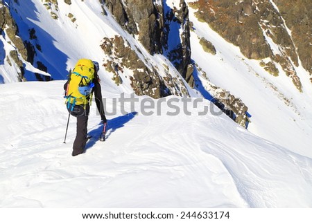 Mountain climber approaching the edge on snow covered summit