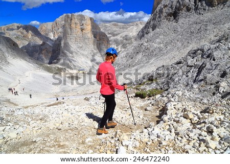 Rocky trail descending to the Vajolet towers and via ferrata climber walking with trekking poles, Catinaccio massif, Dolomite Alps, Italy