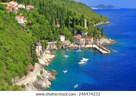 Small traditional harbor surrounded by green hills of Dalmatian coast, Trsteno, Croatia