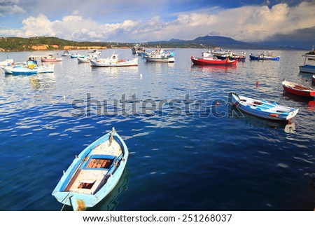 Wooden fishing boats scattered on calm waters of Koroni harbor, Greece