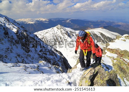 Sunny mountains in winter and team of climbers ascending to the summit