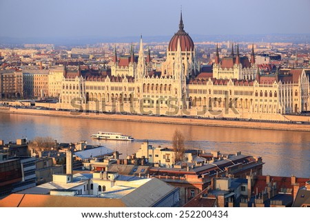 Tourist boat advances on the Danube river in front of the Parliament building in the afternoon, Budapest, Hungary
