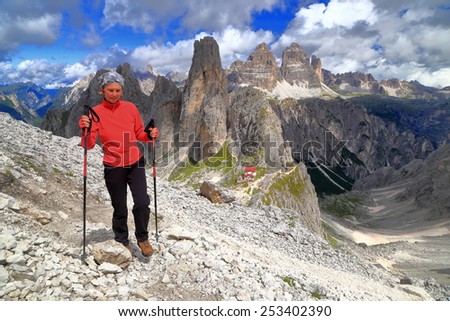 Woman hiker on a trail above the Torre Wundt and Savio Fonda refuge, Cadini di Misurina, Dolomite Alps, Italy