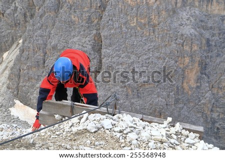 Woman climber at the end of the protection cable of via ferrata \