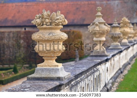Row of decorative pots carved of stone on a fence in medieval garden, Cesky Krumlov, Czech Republic