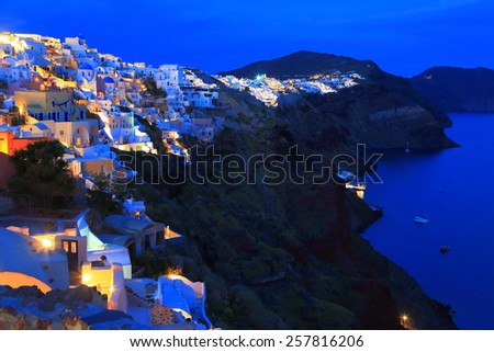 Oia village with traditional houses illuminated at night, Santorini island, Greece