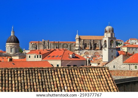 Clock tower and church dome profiled on the blue sky above Dubrovnik old town, Croatia