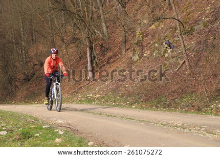 Woman during autumn bike ride on a dirt road