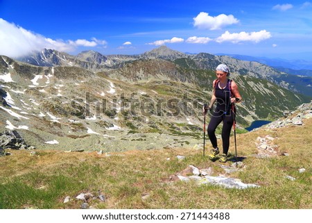 Trail runner woman on sunny mountain slope in summer