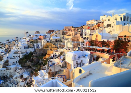 Oia village with white buildings illuminated by the sunset light, Santorini island, Greece