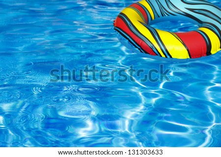 Pool ring, pool float in beautiful clear water of swimming pool with droplets reflecting in the sun. (Selective Focus, Focus on the droplets)