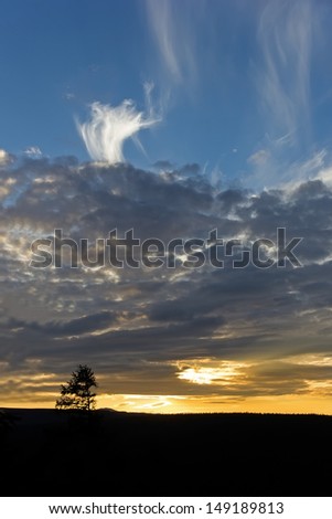 Golden sunset with dark clouds, white clouds and blue sky