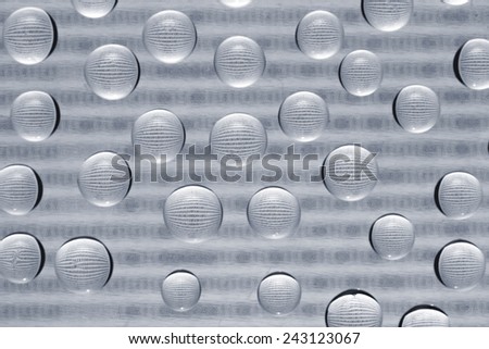 binary code through water drops on glass with a blurred background