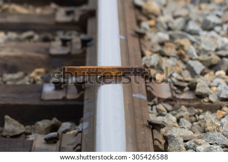 Old, rusty spike-nail which lies on the rail closeup