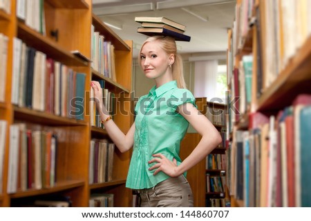 Female university student holding books in library