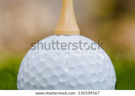 golf tee balancing on top of a golf ball