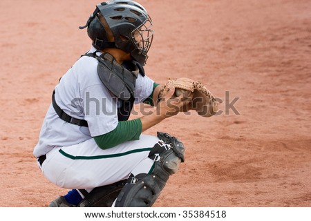 baseball catcher in position with ball in catcher\'s mitt