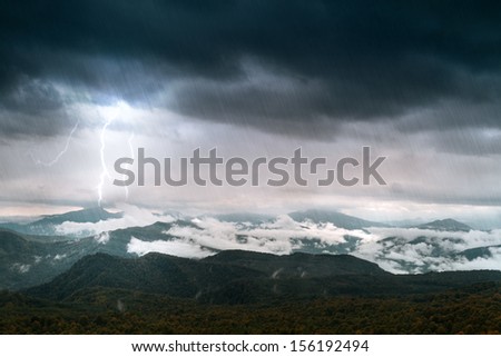 mountain with sky and lighting under rain