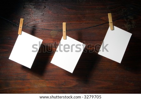 white   paper clothes-peg rope over grunge wood background