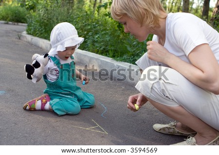 mother and baby drawing chalk on asphalt letter a