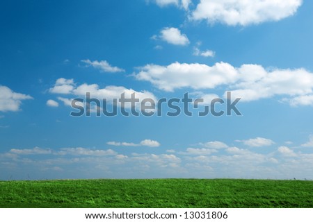 green grass field with blue sky and clouds