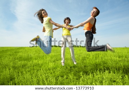three girlfriend jump in green field under blue sky