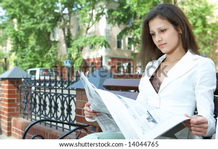 pretty business woman reading the newspaper