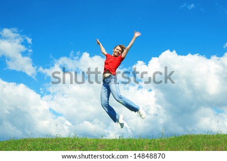 young woman jump on green grass under blue sky
