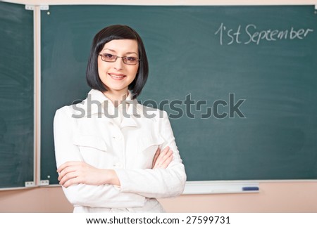 young beauty teacher over green desk