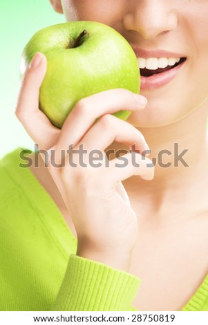 young beauty woman with apple on green background