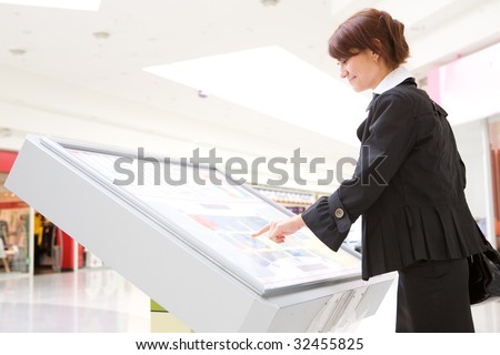young business woman select 	goods on interactive display