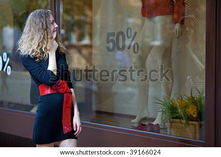 young woman look in shop windows with sale