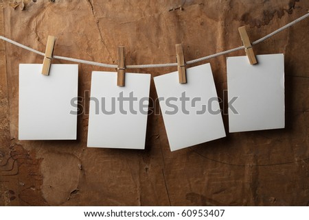 four photo paper attach to rope with clothes pins on paper background