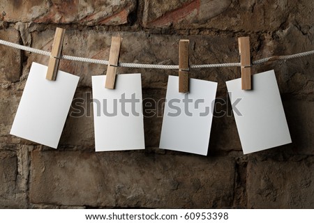 four photo paper attach to rope with clothes pins on brick background