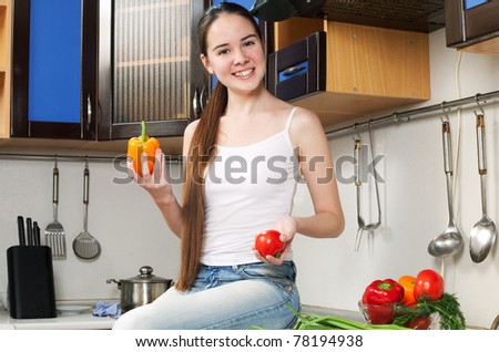 young beautiful caucasian woman in the kitchen with vegetable