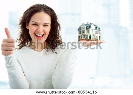 young woman with little house in hand on white