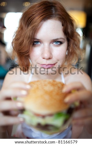 beauty woman in cafe eating hamburger