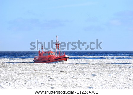 Pilot boat sailing through ice near port of Riga