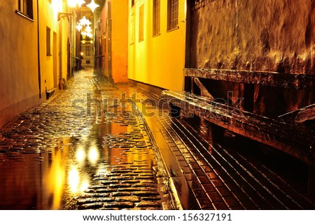 Illuminated street in old part of Riga by night in the rain