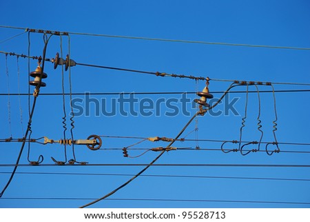 Railroad overhead lines against clear blue sky. Contact wire