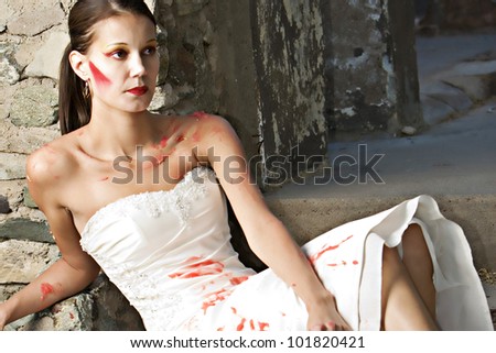 A beautiful bride trashes her dress with red finger paint