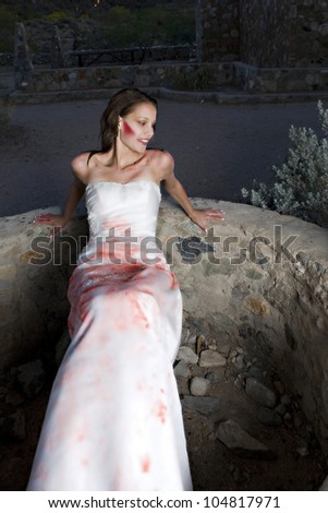 A beautiful bride trashes her wedding dress with red paint