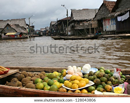 Fruit for sale on a boat. Houses on stilts rise above the polluted water in Belen, Iquitos, Peru. Thousands of people live here in extreme poverty without clean water or sanitation.