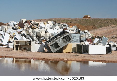 A pile of water heaters, air conditions, and other appliances at a waste dump