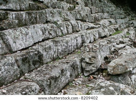 A carved head lies on the ancient steps on the site of Copan - Honduras