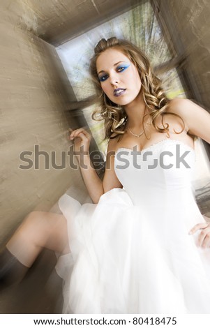 A beautiful bride in a flowing white gown with heavy eye makeup; zoom effect