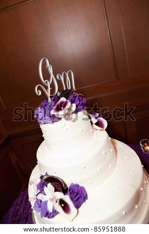 A beautiful white wedding cake with purple flowers