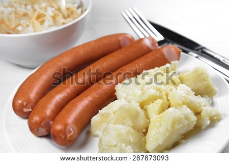 Cooked sausages with potatos and pickled cabbage, shallow focus